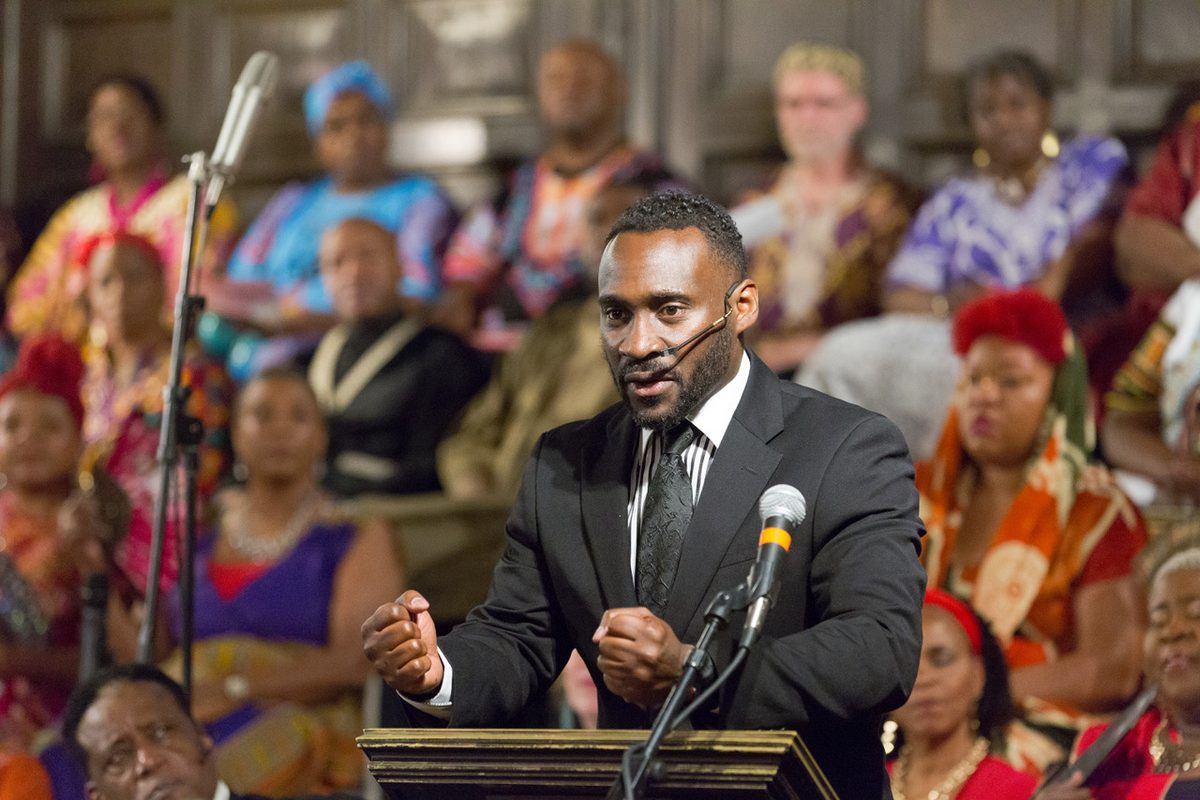 Ajené as the Preacher in Coatesville Cultural Society's The Gospel at Colonus, the choir behind him.